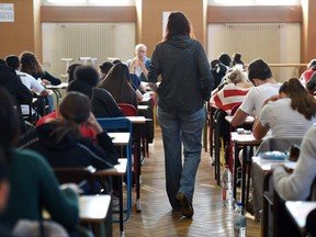 Teacher walks through classrooms while kids sit at desks