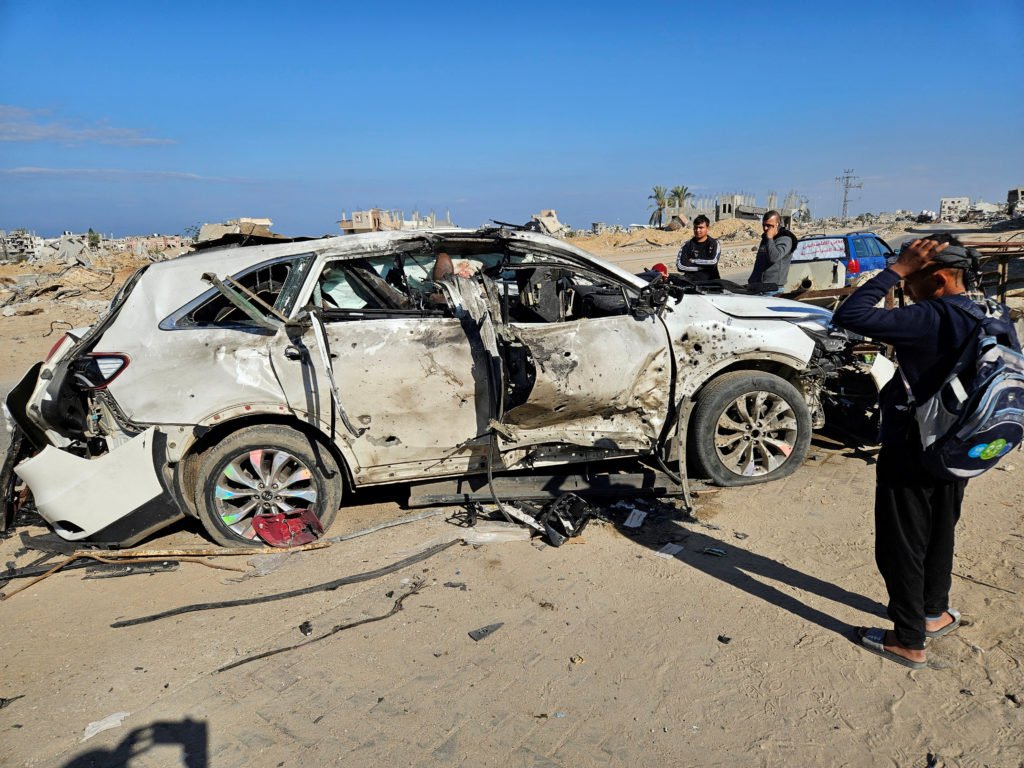 Palestinians inspect a vehicle in which employees of the World Central Kitchen (WCK) were killed in an Israeli strike, in ...