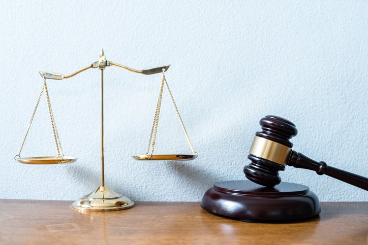 Weight Scale And Hammer On Table Against White Background