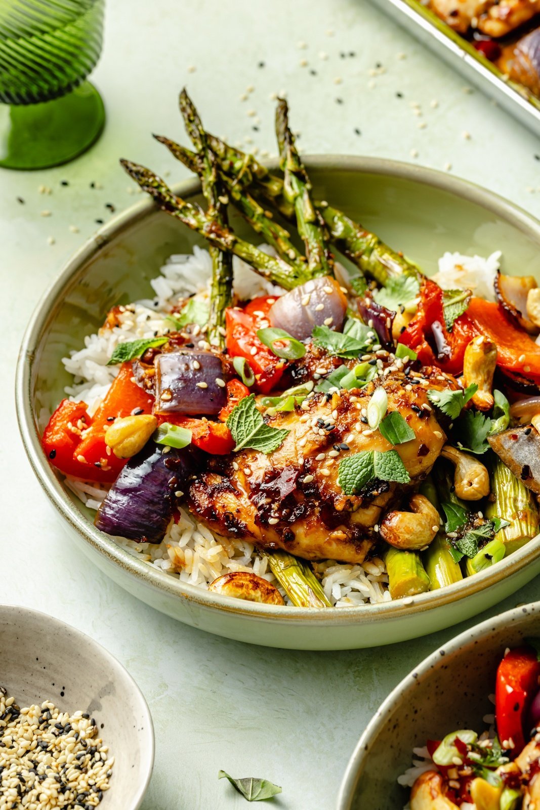 sheet pan sesame chicken and vegetables served in a bowl over rice
